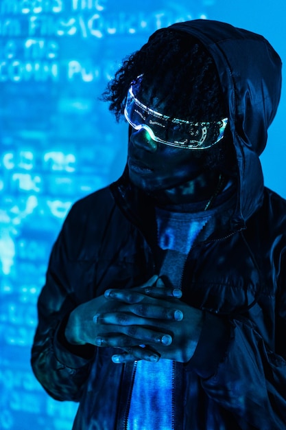 Foto de estudio vertical con luces de neón azules de un hombre futurista con gafas de realidad aumentada