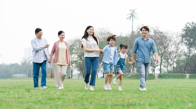 Foto de familia asiática caminando juntos en el parque