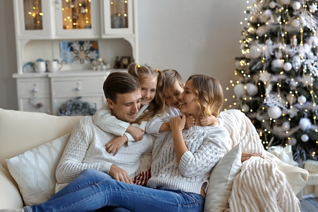 Foto de familia joven feliz sentado en el sofá