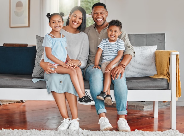 Una foto de una familia joven que se une felizmente en el sofá de casa