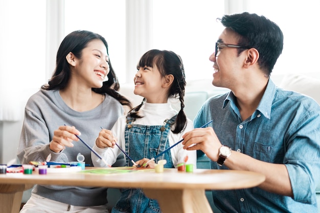 Foto de familia sentada y pintando juntos