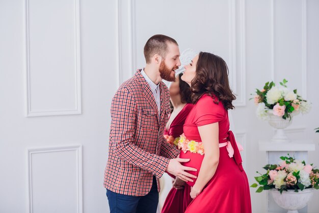 Foto de feliz futuro padre mira a su esposa embarazada. marido y embarazada en un espejo de fondo.