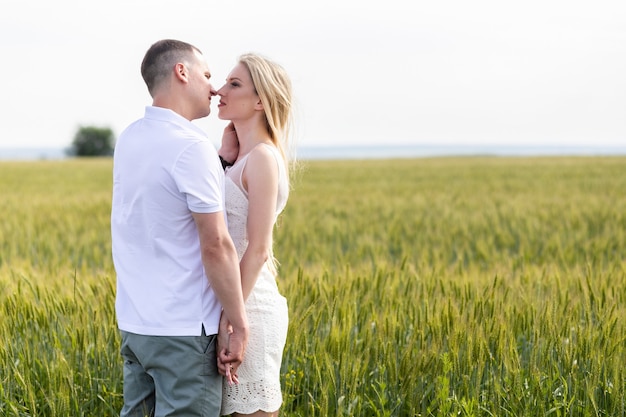 Foto de la feliz pareja abrazándose en el campo de trigo