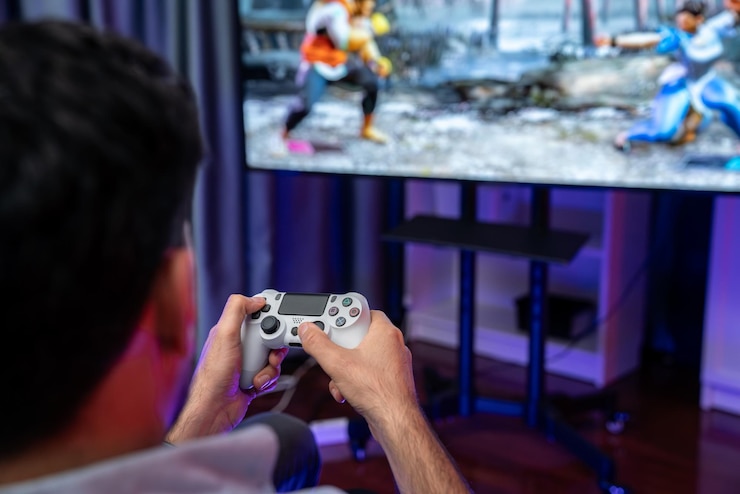 Foto foto focada de segurando joystick com luta competição de jogo de videogame em tela de monitor desfocada controlando o botão do joypad conceito de estilos de vida gamer na sala de estar vendível