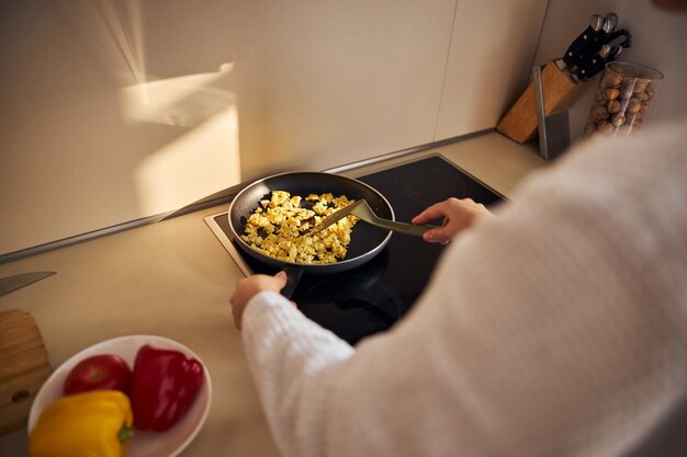 Foto focada na mulher que está cozinhando o jantar