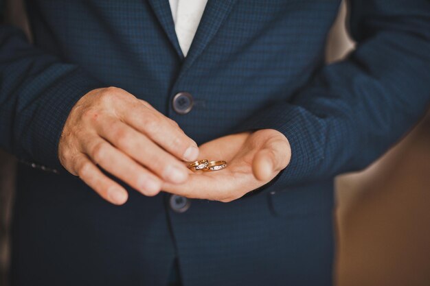 Una foto grande de manos masculinas con anillos de boda 793