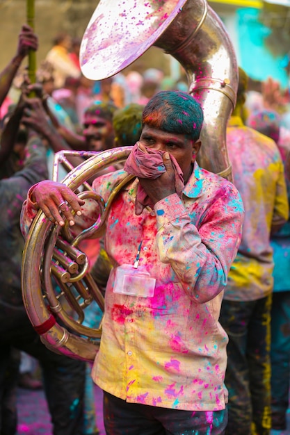 Foto Gratis de Hombre joven indio sosteniendo tuba en Holi Festival