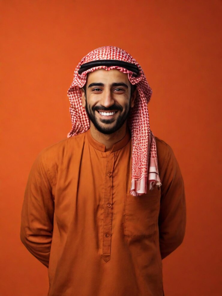 Foto gratis retrato de hombre árabe feliz de un hombre sonriente posando sobre un fondo de estudio naranja