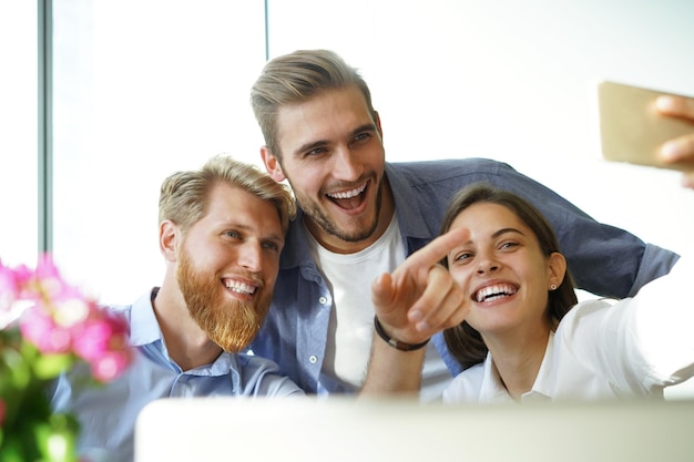 Foto grupal de colegas divirtiéndose en su oficina.