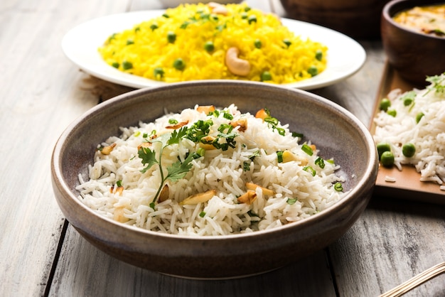 Foto de grupo de arroz indio con guisantes y ajo servido con jeera dal fry, enfoque selectivo