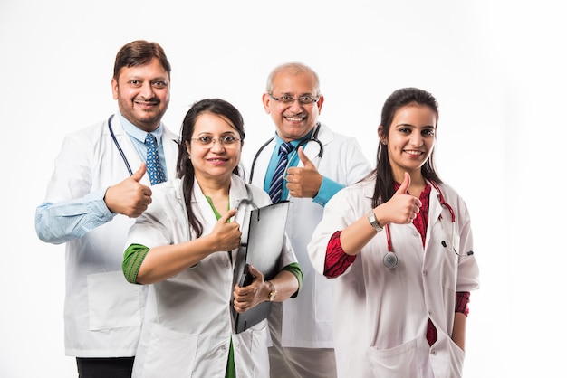 Foto de grupo de médicos asiáticos indios que muestra el éxito o el pulgar hacia arriba. que se encuentran aisladas sobre fondo blanco. enfoque selectivo