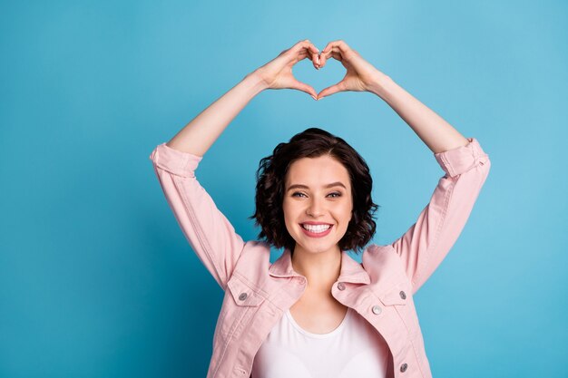 Foto de hermosa dama alegre mantenga los brazos por encima de la cabeza haciendo figura de corazón