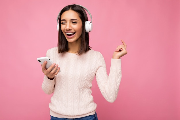 Foto de hermosa joven sonriente alegre vistiendo elegante ropa casual aislado sobre