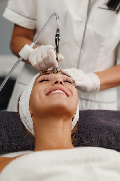 Una foto de una hermosa joven con un tratamiento facial en el salón de belleza.