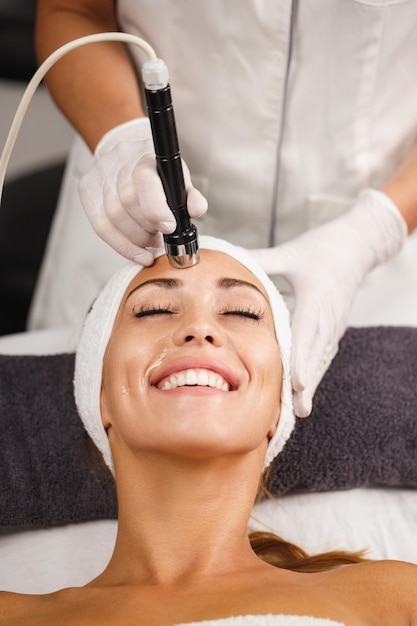 Foto de una hermosa joven en un tratamiento de mesoterapia facial sin agujas en el salón de belleza.