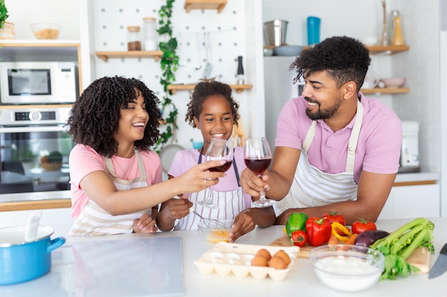 Una foto de una hermosa y linda familia divirtiéndose mientras cocinan juntos en la cocina de casa Linda niña y sus hermosos padres están sonriendo mientras cocinan en la cocina de casa