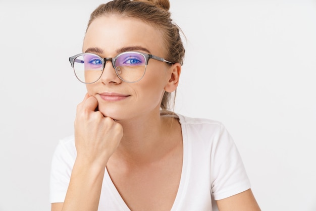 Foto de hermosa mujer complacida en anteojos posando y mirando a cámara