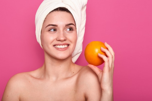 Foto de hermosa mujer joven quiere comer naranja