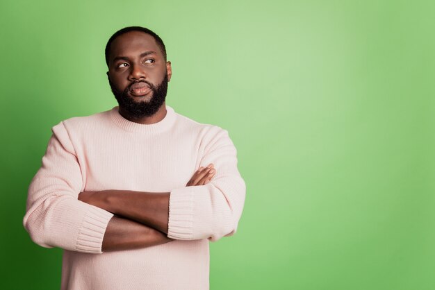 Foto de hombre africano seguro de sí mismo inteligente mentalidad con los brazos cruzados vistiendo camisa blanca sobre fondo verde