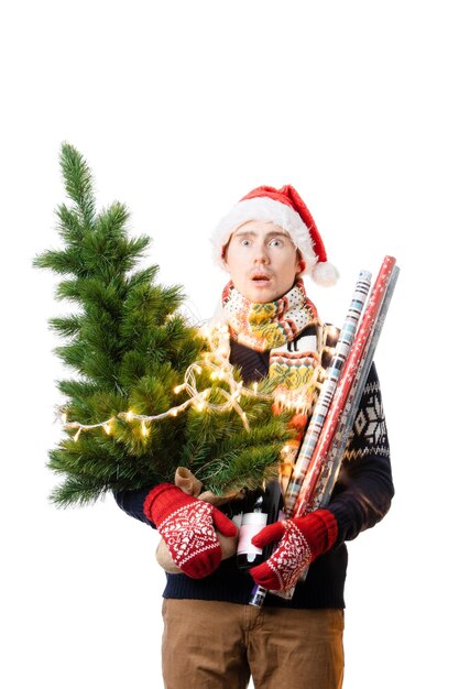 Foto foto de un hombre alegre con gorra de papá noel con un árbol de navidad con una guirnalda de papel de envolver en las manos