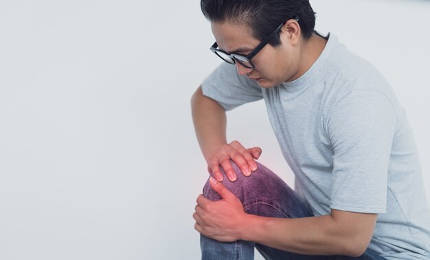 Foto de hombre asiático con dolor de rodilla