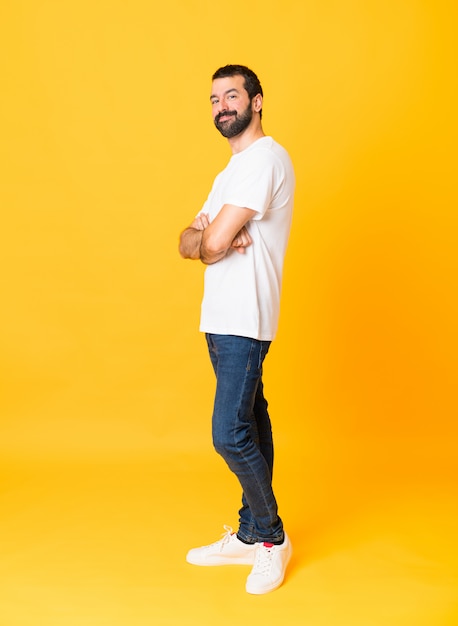 Foto de hombre con barba con los brazos cruzados y mirando hacia adelante