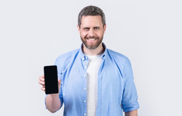 foto de un hombre feliz que muestra la aplicación del teléfono hombre que muestra la aplicación del teléfono aislada en el fondo del estudio hombre que muestra la aplicación del teléfono en el estudio que muestra la aplicación del teléfono