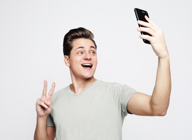 Foto de hombre guapo sonriendo a la cámara tomando selfie