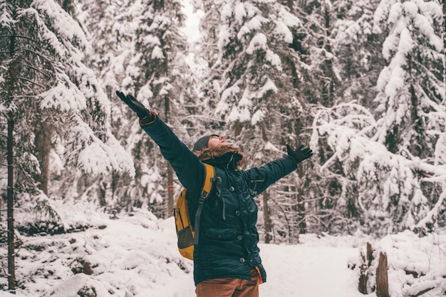 Foto de hombre con las manos en alto para caminar en el bosque de invierno