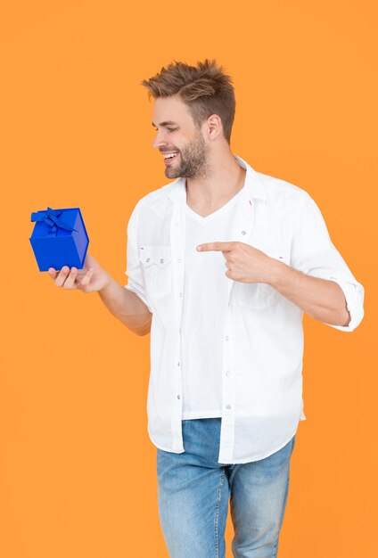 Foto foto de un hombre positivo con una caja de regalos un hombre con un regalo aislado en un hombre blanco con un regalo