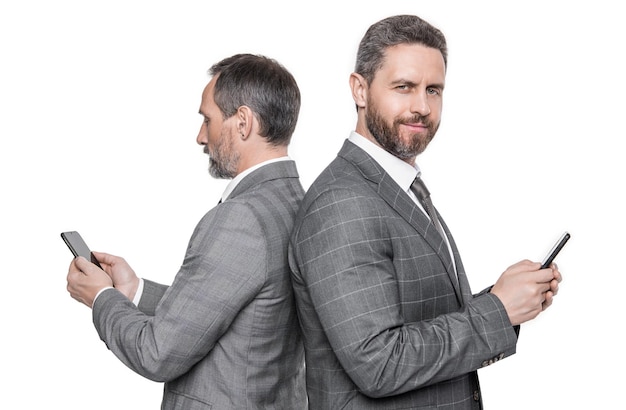 Foto de hombres sonrientes enviando mensajes de texto por teléfono a hombres enviando mensajes de texto en el estudio