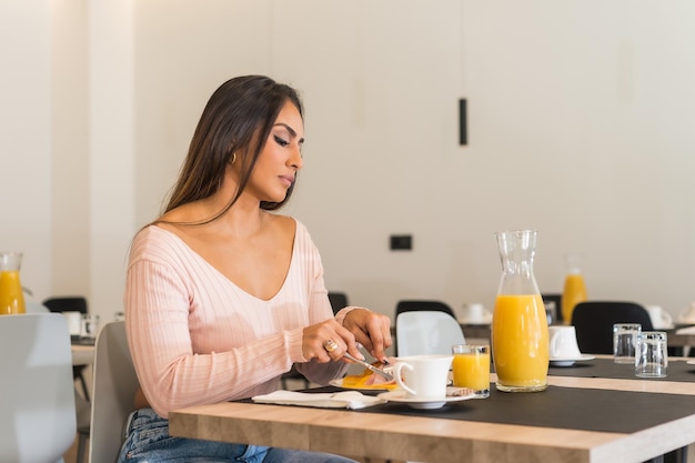 Foto horizontal com espaço de cópia de uma empresária casual tomando café da manhã em um buffet em um hotel