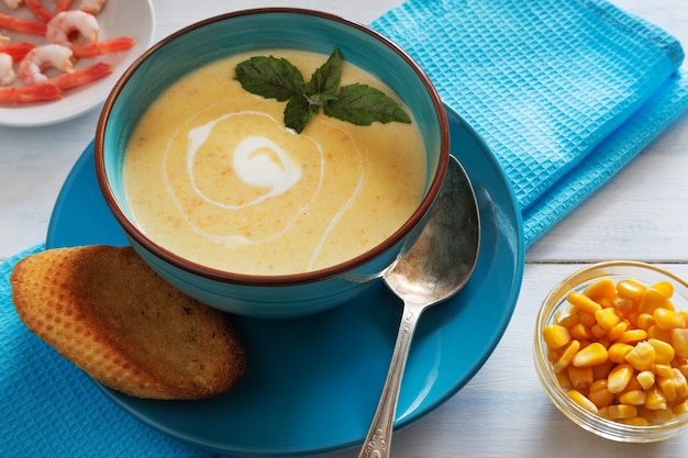 Foto horizontal da tigela de sopa de creme com manjericão