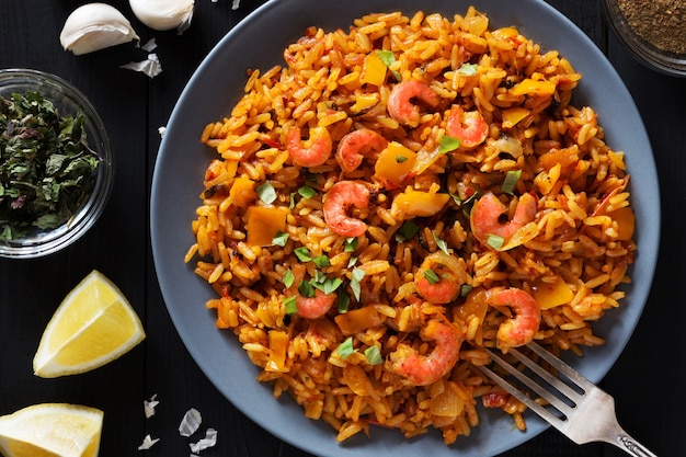 Foto horizontal de arroz frito com camarão, limão e legumes na placa cinza sobrecarga s