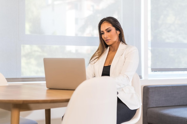 Foto horizontal con espacio de copia de una elegante mujer de negocios que trabaja concentrada usando una computadora portátil