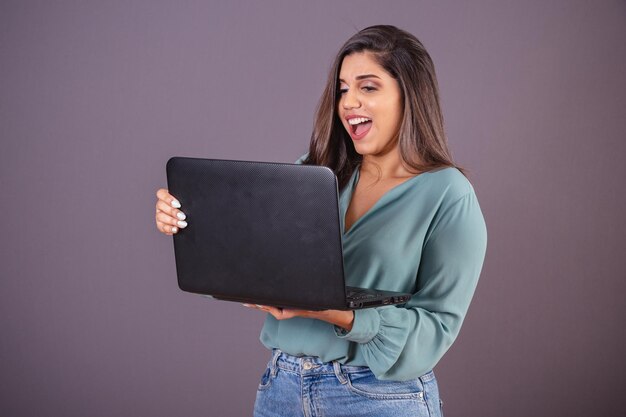 Foto horizontal Hermosa mujer brasileña con ropa casual Jeans y camisa verde con cuaderno