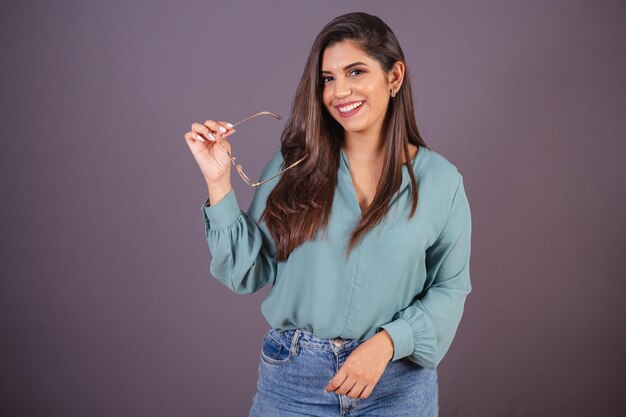 Foto horizontal Hermosa mujer brasileña con ropa casual Jeans y camisa verde con gafas