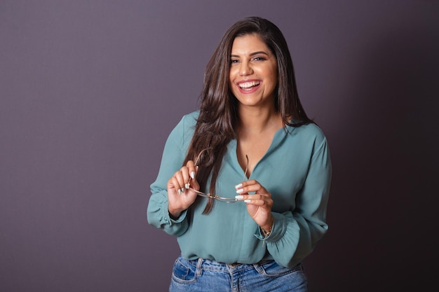 Foto horizontal Hermosa mujer brasileña con ropa casual Jeans y camisa verde con gafas