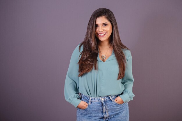 Foto foto horizontal hermosa mujer brasileña con ropa casual jeans y camisa verde manos en el bolsillo sonriendo