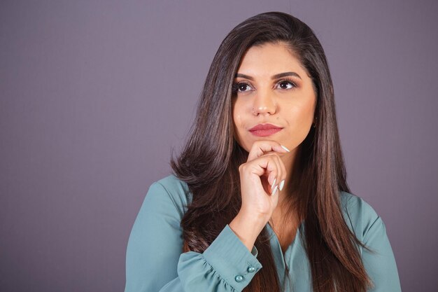 Foto horizontal Hermosa mujer brasileña con ropa casual Jeans y camisa verde signo de reflexión pensando