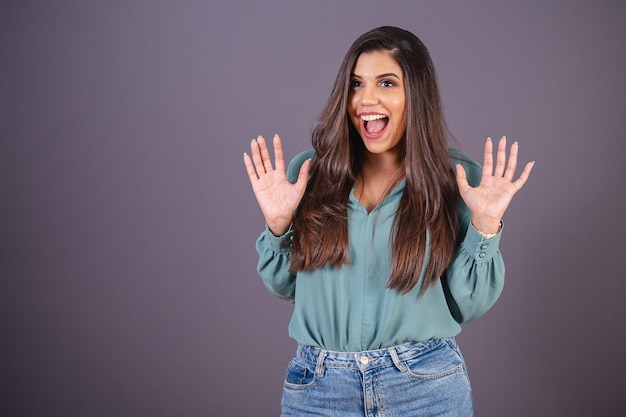 Foto horizontal Hermosa mujer brasileña con ropa casual Jeans y camisa verde Whoa increíble increíble