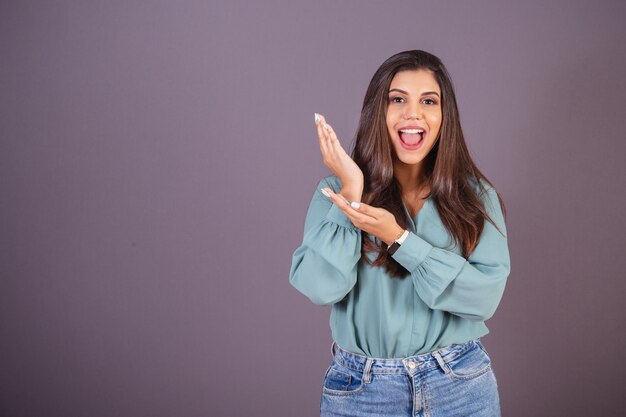 Foto horizontal Linda mulher brasileira com roupas casuais Jeans e camisa verde exibindo publicidade à esquerda