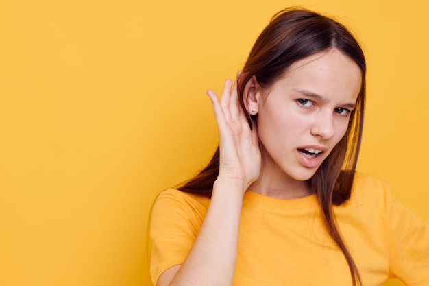 Foto hübsches Mädchen Mode in gelben T-Shirt Jeanshosen gelben Hintergrund