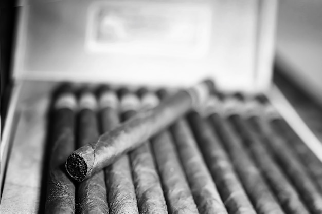 Foto foto im retro-stil einer großen kiste kubanischer zigarren auf einem holztisch in einer ansehnlichen verpackung