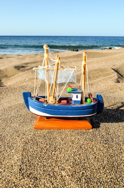 Foto Imagen de un barco de juguete en la playa de arena