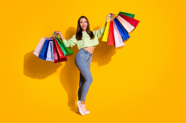 Foto in voller Länge von hübscher Shopaholic-Dame mit vielen Einkaufstüten