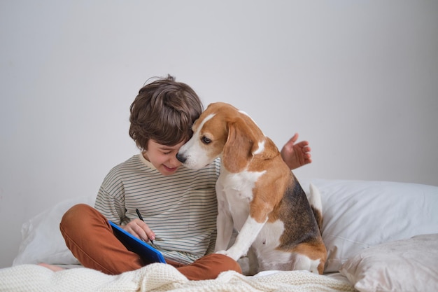 Foto increíblemente dulce de un lindo niño abrazando a su beagle con los ojos cerrados creando un cariñoso