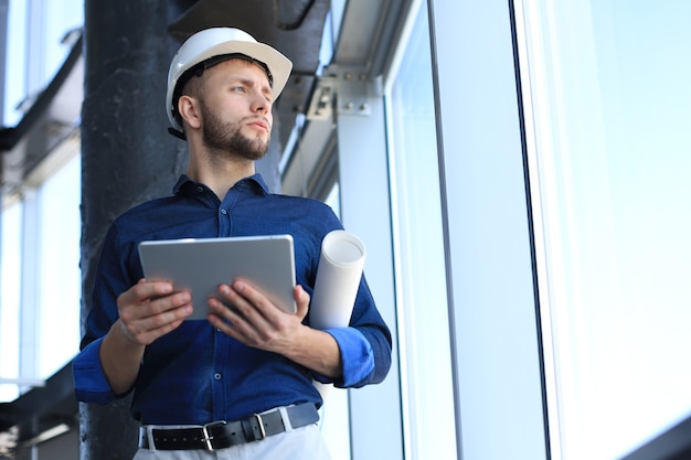 Foto de un ingeniero con una tableta digital en un sitio de construcción. Este software me ayuda a realizar un seguimiento de todo.