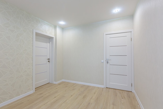 Foto interior de una habitación sin muebles después de la renovación en colores claros.