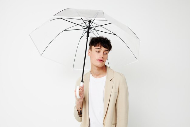 Foto jovem namorado segurando um guarda-chuva nas mãos de posar fundo de luz de moda inalterado